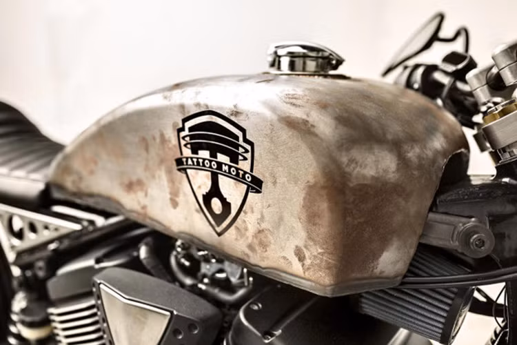 Mặc dù bình xăng độ theo phong cách han rỉ với logo đậm chât cơ khí mang tên Tatto moto nhưng nắp bình xăng lại được phủ một lớp crom sang bóng đến lạ lẫm, không ăn nhập với tổng thể.
