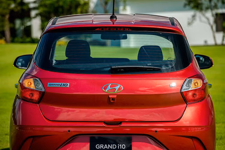 Cải tiến mới của bản Hyundai Grand i10 Htachback là bộ mâm phay bóng 2 màu tươi mới hơn với kích thước 15 inch tiêu chuẩn, tay nắm cửa bọc crom tích hợp nút bấm mở khóa thông minh. Ngoài ra, gương chiếu hậu chỉnh/gập điện tích hợp xi-nhan. Đèn hậu của Hyundai Grand i10 2021 dùng bóng Halogen thường, thiết kế đuôi xe góc cạnh hơn đời cũ.