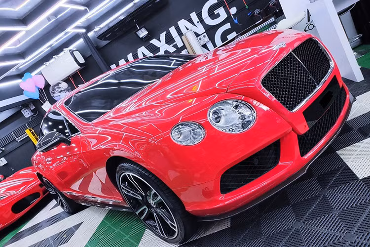 Một chiếc Bentley Continental GT màu đỏ được độ body kit carbon. Phía sau còn có siêu xe Ferrari F430 màu đỏ cũng ấn tượng không kém.