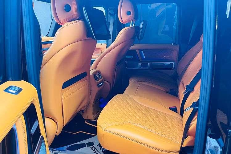 Bên trong khoang lái của chiếc SUV hạng sang Brabus 800 Widestar mới về Phú Quốc định cư có nội y bọc da màu cam hết sức nổi bật cùng nhiều chi tiết được ốp carbon. Hàng ghế phía sau có thêm 2 màn hình giải trí lớn được gắn trên tựa đầu phía sau của hàng ghế trước. 
