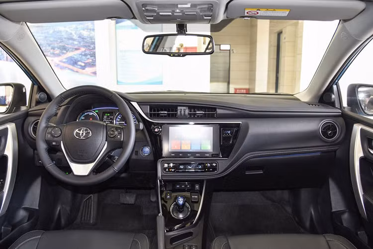 Bên trong Toyota Corolla PHEV 2019 được trang bị màn hình thông tin giải trí nằm bên dưới cửa gió điều hòa. Riêng cần số và nút bấm khởi động máy của mẫu xe này có màu xanh dương như dấu hiệu nhận biết cho xe thân thiện với môi trường.