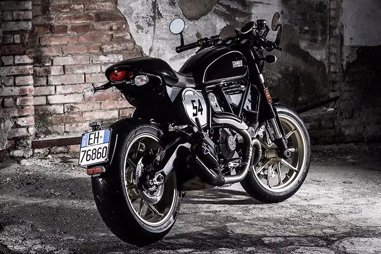 Dựa trên phiên bản Scrambler Full Throttle trước đây, Scrambler Cafe Racer vẫn sử dụng chung nhiều chi tiết quan trọng như khung chính, phuộc, đèn pha, tem xe mới... Tuy nhiên trên mẫu xe mới này ở phía trước, khác biệt đầu tiên của chiếc xe đó là một tấm nhựa bao kín viền đèn pha và phần nối với bảng đồng hồ, khiến chiếc xe trông gọn gàng hơn.