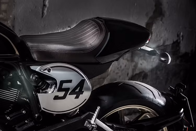 Ducati Scrambler Cafe Racer có trọng lượng chỉ 188 kg và chiều cao yên 805 mm được thiết kế đầy cá tính. Ở hai bên thân xe, Scrambler Cafe Racer có 2 miếng nhôm in số 54 theo đúng phong cách những chiếc xe đua cổ điển. Số 54 mang ý nghĩa gợi nhớ về con số gắn liền với tay đua huyền thoại từng "đầu quân" cho Ducati là Bruno Spaggiari.