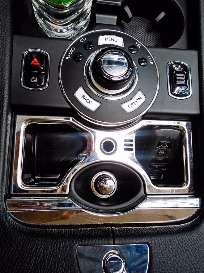 Bệ tỳ tay trung tâm của chiếc Rolls-Royce Ghost siêu sang với bảng chức năng bọc da thật và mạ chrome. Chìa khóa Keyless không cần tra vào ổ được đặt trong hộc thể hiện đẳng cấp của dòng siêu xe có tiếng này.