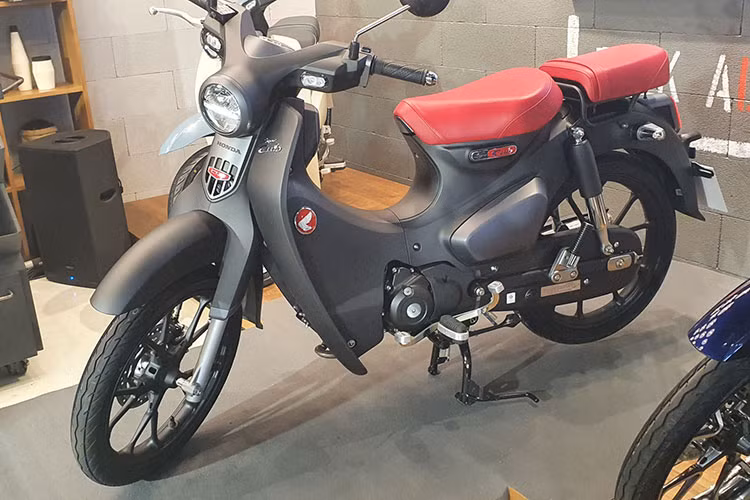 Điểm nhấn đáng chú ý của Honda Super Cub thế hệ mới chính là phiên bản màu Đen mờ mới với dàn áo, bộ vành màu đen mờ lịch lãm và mạnh mẽ. Nổi bật trên đó là bộ yên hai mảnh cùng logo xe màu đổ rất nổi bật.