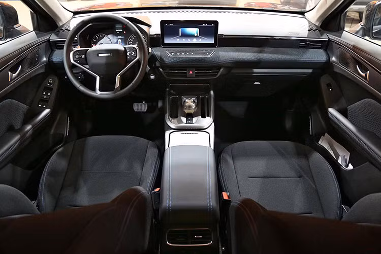 Nhờ kích thước lớn nên nội thất bên trong Haval Jolion 2022 khá rộng rãi. Nhiều chi tiết nội thất như mặt táp-lô, màn hình thông tin giải trí và hàng nút chỉnh bên dưới được thiết kế nằm ngang, tạo cảm giác rộng rãi hơn nữa. Bên cạnh đó, nội thất còn đi kèm những điểm nhấn màu vàng đồng như ở vô lăng, mặt táp-lô, cụm điều khiển trung tâm và hai bên cửa.