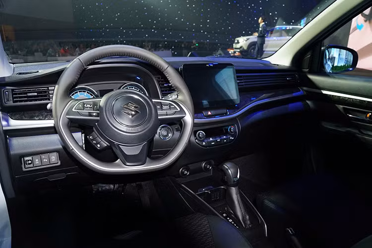 Bên trong xe, Suzuki XL7 Hybrid được trang bị trần xe màu xám nhạt mới thay cho màu be cũ, kết hợp cùng viền trang trí màu bạc liền mạch từ cửa hông, qua khu vực bảng điều khiển và vô lăng. Chi tiết ốp nhựa trang trí trên cánh cửa cũng được đổi mới thành họa tiết vân gỗ mới.