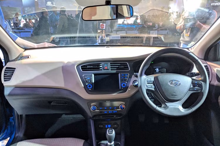 Ở bên trong, không gian của Hyundai i20 2018 facelift sẽ là các tùy chọn cửa gió điều hòa màu cam hay đỏ phụ thuộc tông màu (đỏ - trần đen). Khu vực bảng điều khiển khá đơn giản bao gồm vô-lăng 3 chấu tích hợp một vài phím chức năng cơ bản, điều hòa không khí vùng tập trung ở chính giữa bảng táp-lô, ghế ngồi bọc vải nỉ thông thường.