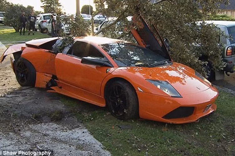 Khi đang khoe sức mạnh” "siêu bò" Lamborghini Murcielago cho khách đến mua xe xem - chủ nhân siêu xe màu cam tại Sydney, Úc đã mất lái và lao sang bên đường đâm bật gốc 1 cái cây.