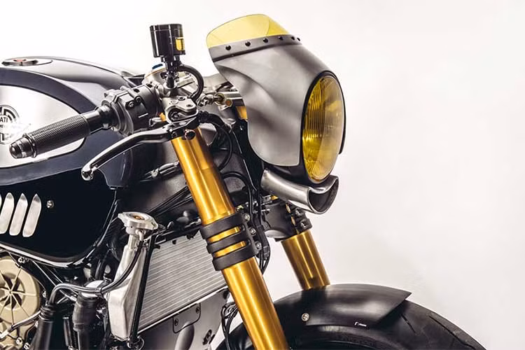 Bộ đèn LED kép nguyên bản của Panigale R hoàn toàn không ăn nhập với kiểu dáng của một chiếc cafe racer, chính vì vậy chóa đèn tròn màu vàng cổ điển đã được thay thế cho chiếc xe. Bao xung quanh bộ đèn, Raphael đã gò cho chiếc xe một chiếc quây gió mini. Đặc biệt, anh còn tự tạo ra một khe hút gió bằng nhôm nằm dưới đèn pha.