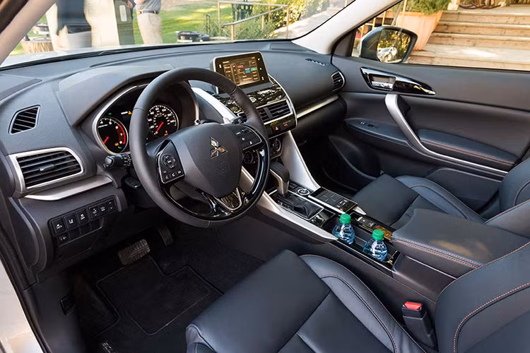Bên trong nội thất, bảng táp-lô của Eclipse Cross thiết kế chia tầng rõ rệt. Những đường viền ốp chạy ngang bảng táp-lô, cắt dọc từ bệ trung tâm màu kim loại đem tới cho xe cảm giác hiện đại, năng động hơn. Vô-lăng trên mẫu xe này thiết kế 3 chấu, bọc da được lấy cảm hứng từ Outlander.