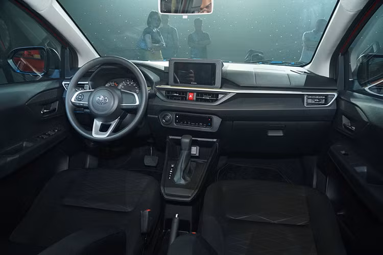 Khoang nội thất Toyota Wigo 2023 cũng thay đổi hoàn toàn với gam màu đen chủ đạo cùng thiết kế thể thao, lấy người lái làm trung tâm. Cần số bố trí cao hơn, phía sau vô lăng xuất hiện lẫy chuyển số, đồng hồ vẫn dạng analog, màn hình giải trí trung tâm hiện đại hơn với thiết kế đặt nổi và tương thích với Apple CarPlay/Android Auto.