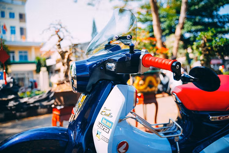 Để lấp đầy khoảng trống phần đầu xe do thiết kế quá nhỏ bé cuả Super Cub C125, chủ xe đã trang bị kính chắn gió Asahi xuất xứ từ Japan, vừa tăng độ thẩm mỹ mà còn cản gió tốt hơn. Cánh trái được trang bị kính gù CNC Racing siêu nhỏ gọn, khả năng nhìn về sau cũng đáp ứng tốt nhưng góc nhìn thực sự khá hẹp, chỉ thích hợp đi kiểng.