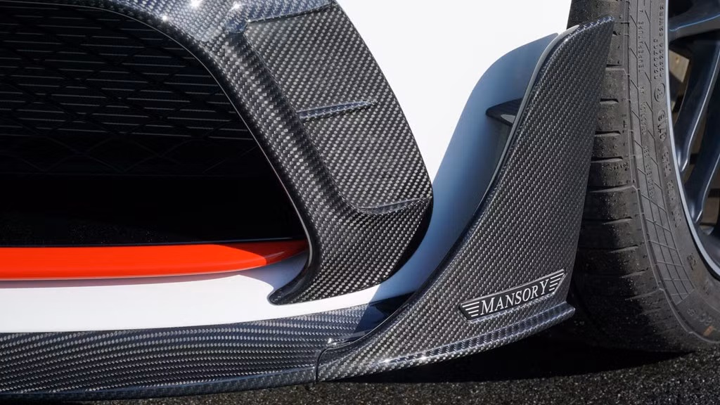 Điều không thể thiếu ở mỗi sản phẩm mang thương hiệu độ Mansory, vật liệu sợi carbon được hãng độ áp dụng trên nhiều bộ phận của AMG C63 như viền lưới tản nhiệt dưới, thanh cản trước, vỏ gương và hốc gió hai bên thân xe.