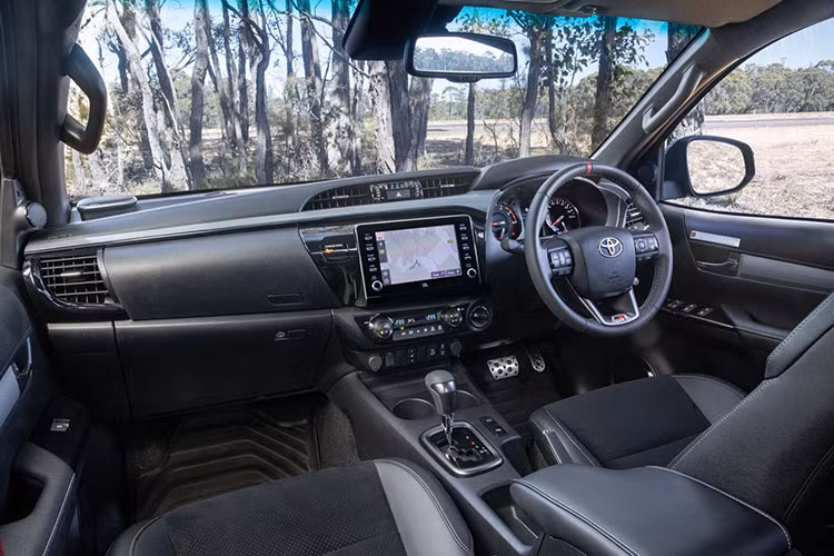 Toyota Hilux GR Sport 2024 với thiết kế hầm hố, vạm vỡ và nhận được sự kỳ vọng rất lớn từ phía Toyota Australia. Bên trong xe được trang bị vô lăng bọc da với lẫy chuyển số có đường chỉ màu đỏ ở trung tâm và dòng logo GR đặt ở đáy vô lăng. 