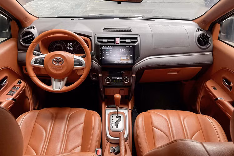 Bên trong, Toyota Rush 2019 sở hữu không gian nội thất được bố trí đơn giản nhưng thực dụng. Xe trang bị vô lăng 3 chấu đa chức năng, khởi động nút bấm Start/Stop và một màn hình giải trí cảm ứng đặt ở vị trí trung tâm, dễ thao tác. Cụm đồng hồ hiển thị lấy cảm hứng từ Fortuner với hai đồng hồ analog và một màn hình TFT chính giữa, cung cấp đầy đủ thông tin vận hành.