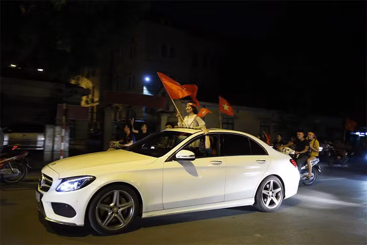 Một chiếc xe sang Mercedes-Benz được chủ nhân mở mui vẫy cờ đỏ sao vàng ủng hộ đội tuyển Olympic Việt Nam sau chiến thắng lịch sử.