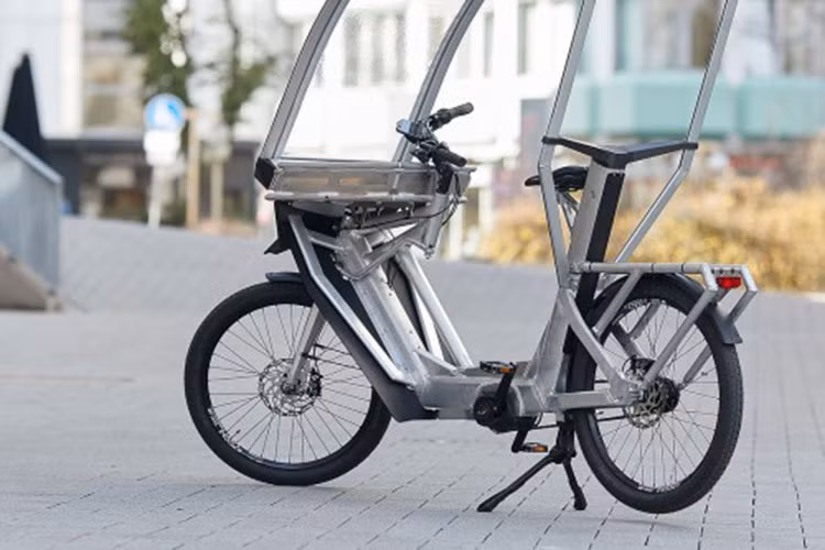 Mong muốn đưa ra một giải pháp mới tốt hơn, một người đi xe đạp kiêm doanh nhân Đức có tên Tom Eisner đã sáng chế ra một phương tiện gọi là AllWeatherBike chạy điện, gọi tắt là xe đạp điện AWB.