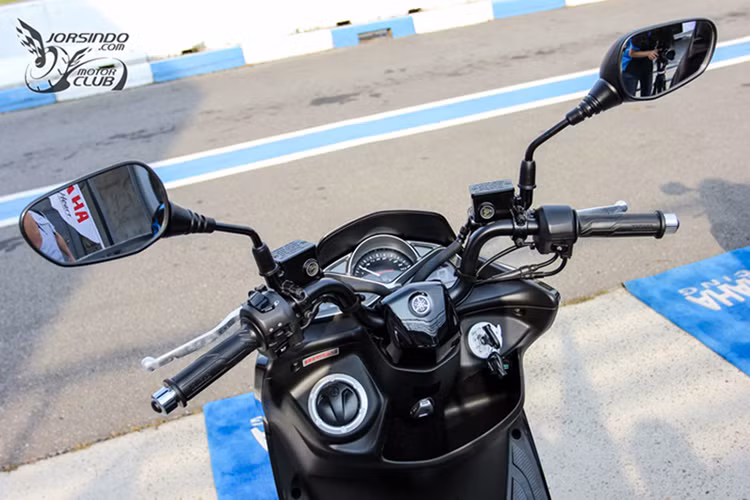 Yamaha SMax 155 ABS được thiết kế với ghi đồng trần khá rộng, tuơng tự Honda PCX, tuy nhiên trên mẫu xe này nhiều chi tiết như các nút bấm khác khác biệt, đặc biệt chi tiết cồi báo vẫn theo kiểu truyền thống chứ không đưa lên cao như "đối thủ đồng hương" Honda PCX 150. 