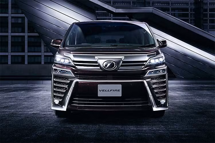 Vellfire mới sở hữu thiết kế đậm nét và khỏe khoắn hơn so với đàn anh "sang chảnh" Alphard. Lưới tản nhiệt của xe gồm các thanh ngang cực lớn, ngay bên cạnh là đèn pha và đèn demi LED sắc sảo được tách thành 2 phần. Xe sở hữu bộ mâm 18 inch dạng nan và cột B vát góc.
