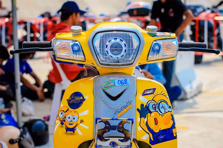 Trong mắt những dân chơi xe máy Châu Á, đặc biệt là Thái Lan - mẫu Super Cub 110 vẫn là một mẫu "xe chơi" theo phong cách độ kiểng và chiếc xe trong bài viết này là một ví dụ. Về ngoại hình, nó được khoác lên bộ áo vàng rực rỡ được kết hợp cùng nhân vật trong bộ phim hoạt hình mà rất được các bạn nhỏ yêu thích đó chính là Minions .