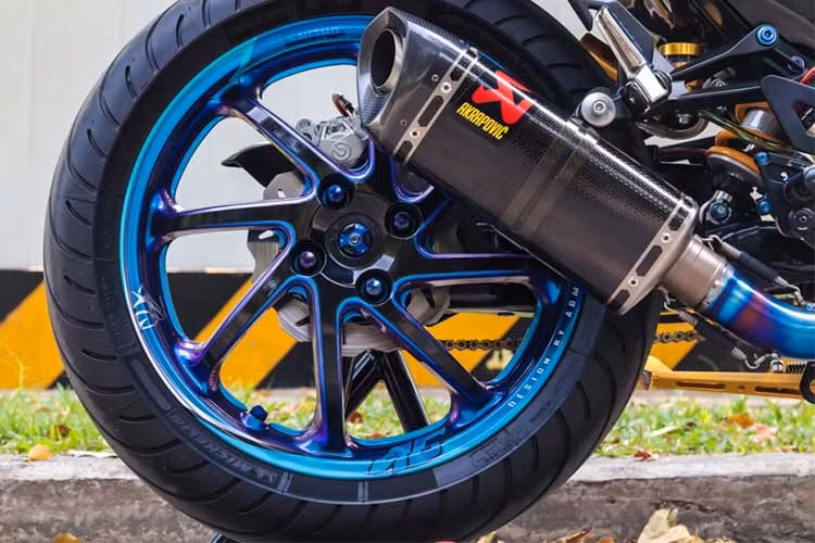 Hệ thống ống xả của hãng Akapovic dành riêng cho dòng Yamaha MT09 cũng được lắp vào chiêc Yamaha Exciter độ này. Việc trang bị dàn chân từ chiếc Honda NSR150 với gắp đơn sau tạo kiểu dáng hầm hố cho chiếc xe hơn. Heo sau của hãng Brembo được bắt ở vị trí khá đẹp làm lộ rõ hệ thống an toàn.
