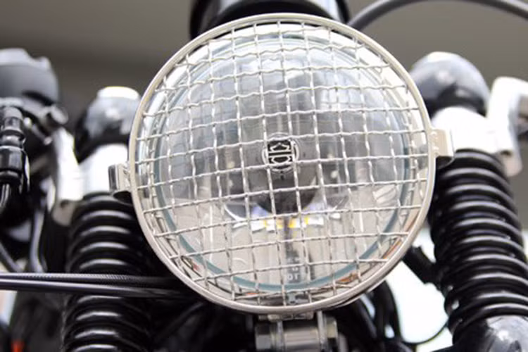 Đèn pha vẫn mang logo thương hiệu Harley-Davidson nhưng được chủ xe độ thêm khung lưới mắt cáo giúp chiếc xe cá tính hơn.
