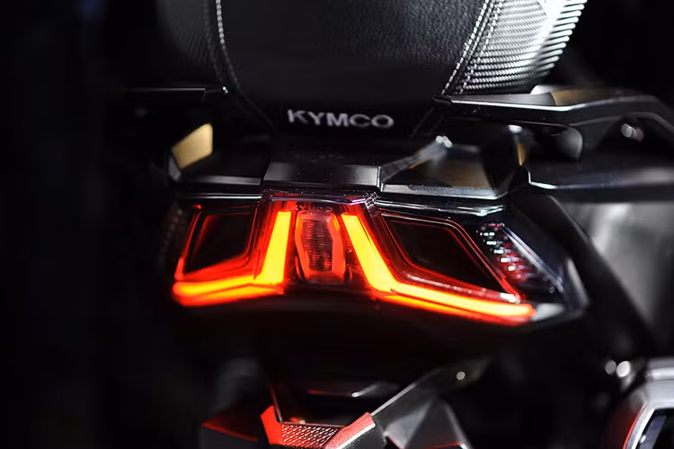 Đuôi xe của Kymco AK 550 2018 thuôn dài với đèn xi-nhan tích hợp trong đèn hậu dạng full led. Ngay bên dưới yên là khu vực cốp xe rộng rãi được trang bị hệ thống xạc thiết bị di động, không gian đủ cho một nón bảo hiểm full-face và nhiều đồ đạc khác. Vị trí nắp bình xăng nằm ngay trước mũi yên cũng dễ dàng cho việc sử dụng và tiếp nhiên liệu.