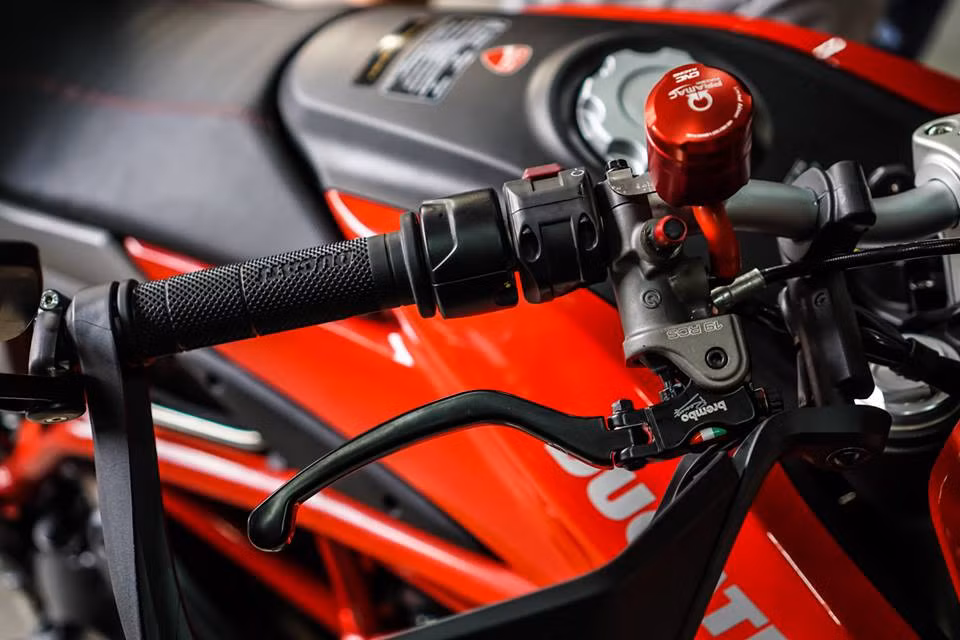 Hệ thống phanh trên chiếc xe Hypermotard 939 này cũng đã được chủ nhân nâng cấp với cùm phanh dầu Brembo RCS 19 với sự hỗ trợ từ bình dầu CNC Racing và núp chỉnh gió Stahlbus. Phía bên trái tay lái là bộ cùm côn dầu Brembo RCS 16 cùng với đó là cặp kiếng CRG Arrow.
