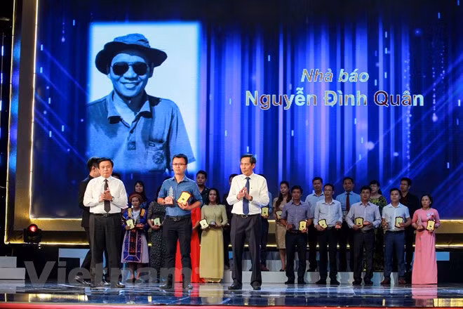 Trong các tác giả đoạt giải C có nhà báo Nguyễn Đình Quân, phóng viên thường trú báo Tiền Phong tại Khánh Hòa đã không may qua đời trong một vụ tai nạn giao thông. Con trai ông đã lên nhận giải cũng như nhận sự tri ân của những đồng nghiệp. (Ảnh: Minh Sơn/Vietnam+)