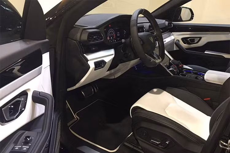 Đối lập bộ áo ghi sáng, bên trong khoang lái chiếc siêu SUV Lamborghini Urus mới đầu tiên cập bến Campuchia có nội thất bọc da 2 tông màu là trắng và đen. Đây là 2 màu sắc tương phản và dễ dàng mang đến sự nổi bật cho "nội y" chiếc siêu SUV Urus đầu tiên tại xứ sở chùa tháp.
