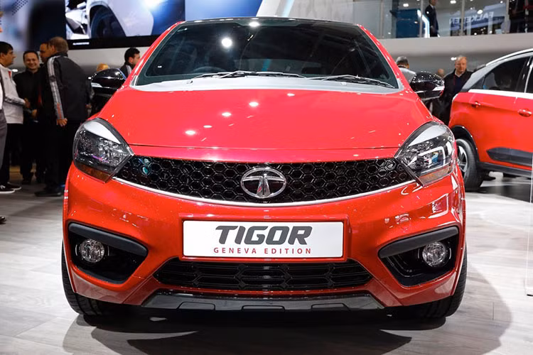 Tata Tigor sở hữu phần đầu không có gì nổi bật, thậm chí nếu nhìn kỹ bạn sẽ tưởng tượng ra một số chi tiết của dòng xe nổi tiếng nào đó. Lưới tản nhiệt của xe được thiết kế dạng tổ ong với logo Tata chính giữa, trang bị phần đầu với đèn pha halogen và cụm đèn sương mù bên dưới.