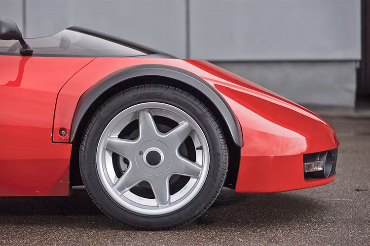 Tên của chiếc xe độc nhất vô nhị này thường được gọi là siêu xe Ferrari Conciso (tạm bỏ qua thương hiệu Lotus). Nó sở hữu phần khung xe tự chế và được thiết kế dựa theo nguyên lý phát triển của mẫu siêu xe đàn anh Ferrari 328 GTS vào năm 1989 với hình dáng xe không cửa. 