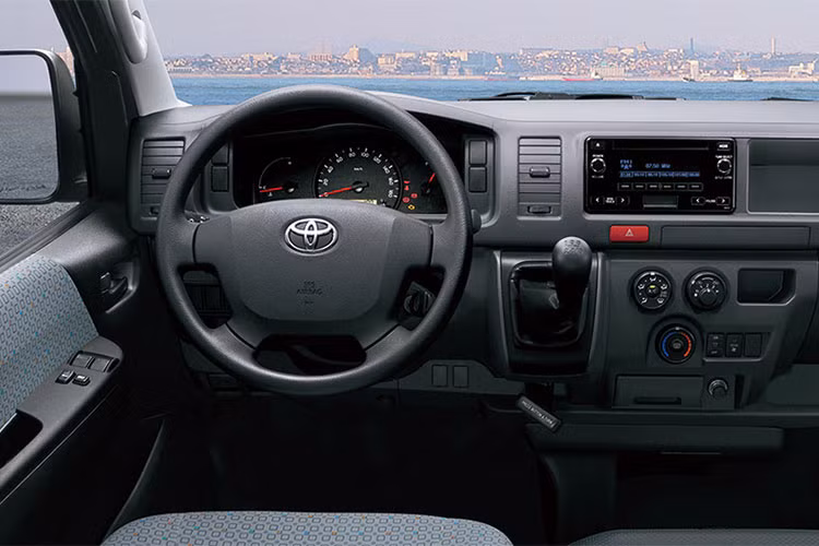 Một trong những ưu điểm khiến Toyota Hiace được đánh giá cao là phần thiết kế nội thất vô cùng rộng rãi và tiện nghi. Vô lăng thiết kế dạng 4 chấu, cùng việc trang bị trợ lái thủy lực khiến người sử dụng có cảm giác lái đầm hơn so với trợ lái điện. Trên bảng táp-lô có hệ thống thông tin giải trí với đầy đủ các kết nối như Bluetooth, AUX, USB, AM/FM...
