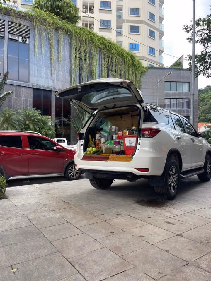Một hàng trà đá được bày bán trước cửa 1 tòa văn phòng.