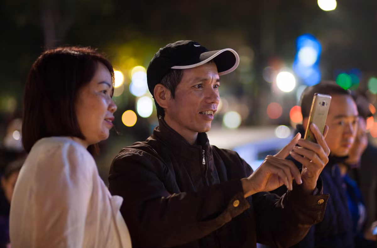 Nhiều người trung niên, người cao tuổi cũng không bỏ lỡ cơ hội "hòa cùng lớp trẻ", dùng điện thoại chụp ảnh trong thời khắc giao thừa.
