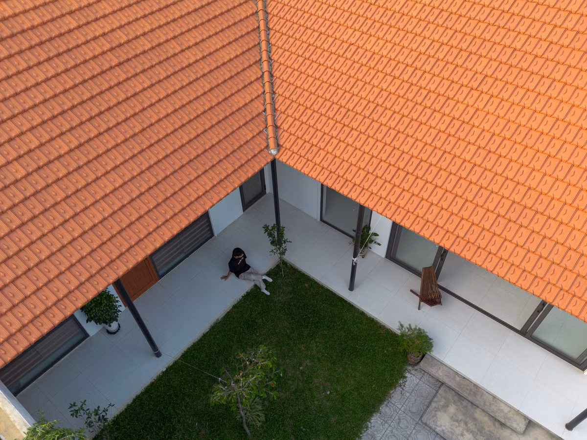 Nhìn từ bên ngoài, ngôi nhà mang đến cảm giác mộc mạc, thân quen với những hình khối đơn giản, vật liệu bản địa như đá, gỗ, và mái ngói đỏ...Ảnh: Lê Trung
