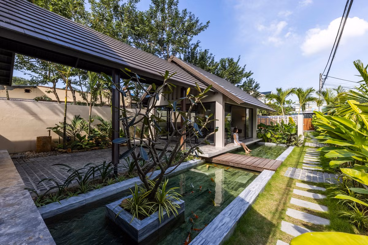Lối vào nhà qua một hành lang xanh tươi và một lối đi bằng đá tự nhiên và một hồ cá Koi, giúp tăng cường bầu không khí trong lành. Ảnh: Hiroyuki Oki