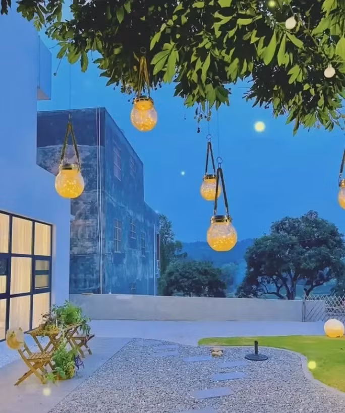 Đi qua cổng gỗ là sân vườn rộng lớn với bãi cỏ, lối đi lát đá và nhiều loại cây cỏ và hoa. Ảnh: Sohu