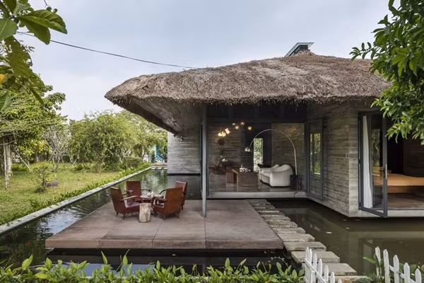 Căn biệt thự thiết kế với 5 khối riêng biệt và được bố trí ngẫu hứng dưới mái tranh lớn, bao quanh là hồ cá koi. Ảnh: Hiroyuki Oki