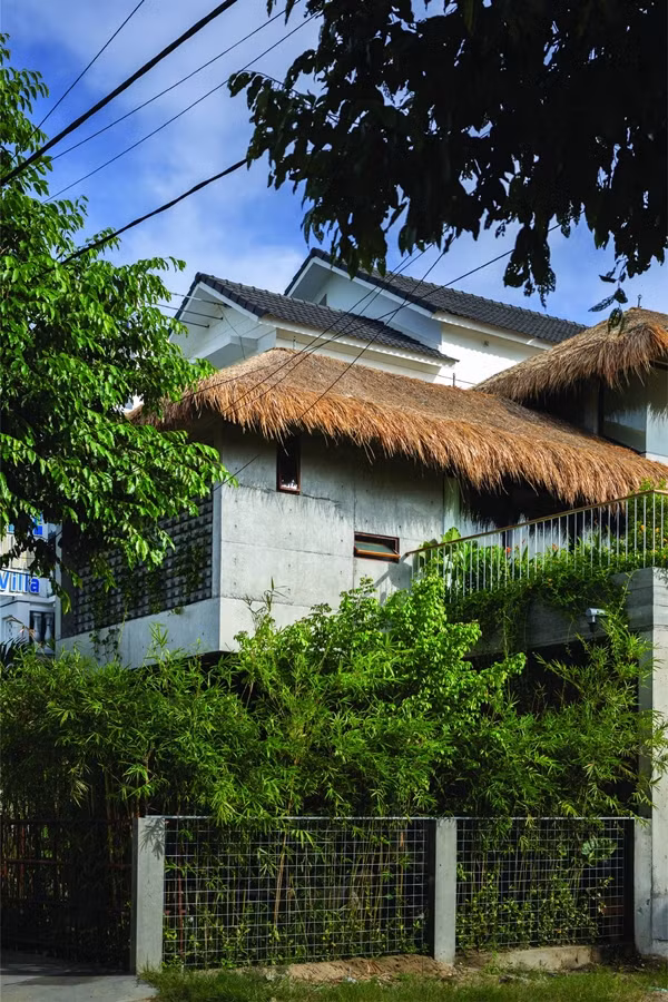 Nổi bật là lợp mái tranh trên mái bê tông, tạo sự mát mẻ và thân thiện với môi trường. Ảnh: SuKha_Studio