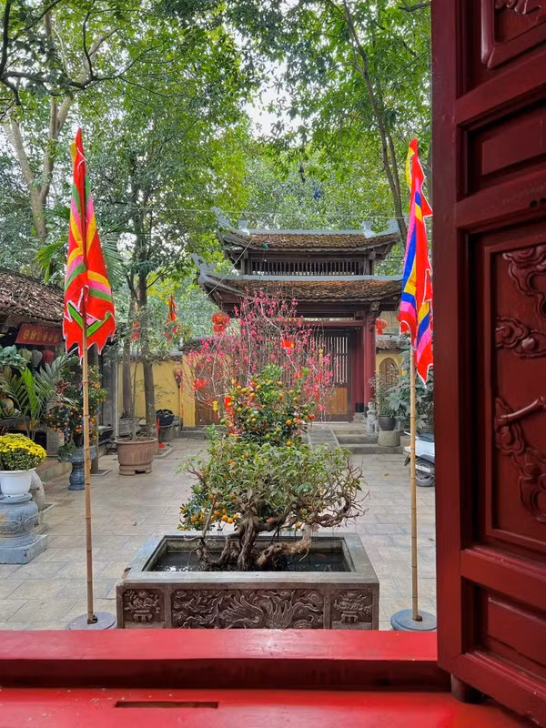 Từ ngoài bước vào, nổi bật là chiếc cổng hai tầng tám mái bằng gỗ sơn son. Đây là điểm nhấn hút mắt cho biệt phủ bên cạnh những ngôi nhà nông thôn đang dần thay áo mới. Ảnh: FBNV