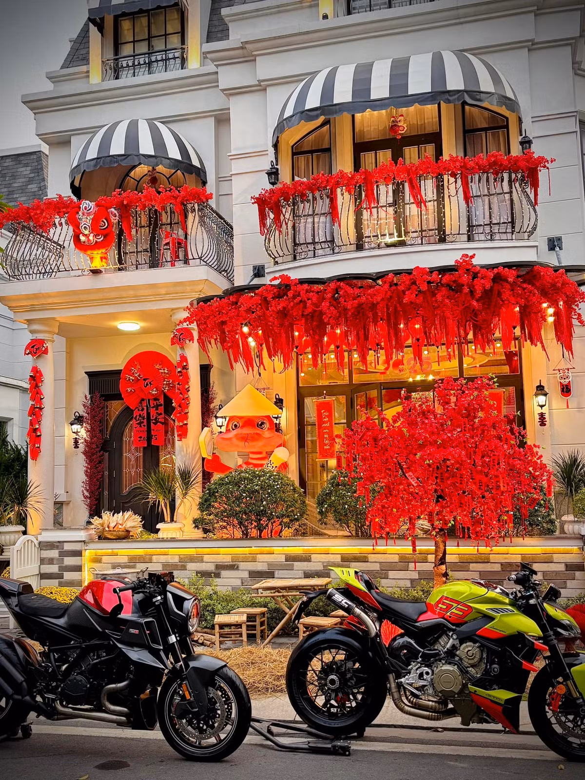 Ban công phủ kín hoa đỏ và điểm nhấn là các mô hình đầu lân, biểu tượng của sự may mắn và thịnh vượng. Ảnh: FB Đoàn Di Băng