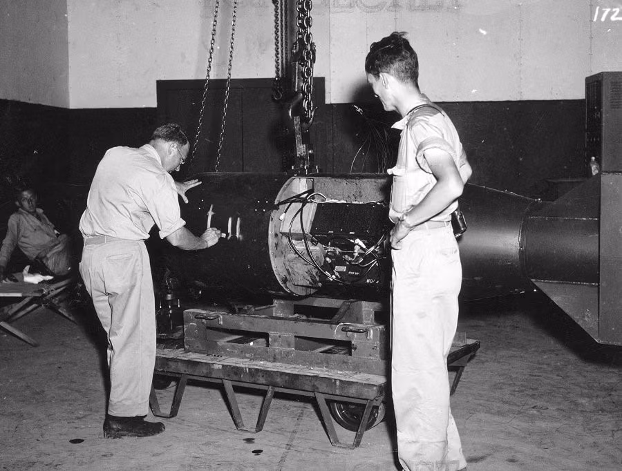 Nhà nghiên cứu địa vật lý Francis Birch (trái) đánh dấu quả bom sẽ trở thành "Little Boy". Nhà vật lý Norman Ramsey, thành viên Dự án Manhattan đứng bên cạnh, người sau này nhận giải Nobel Vật lý.