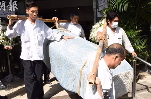 Linh cữu Kim Dung được khiêng lên xe. Sau khi hỏa táng, tro cốt nhà văn được đặt tại Bảo Liên Thiền Tự - ngôi chùa nổi tiếng ở Hong Kong, nằm ở Đại Nhĩ Sơn.