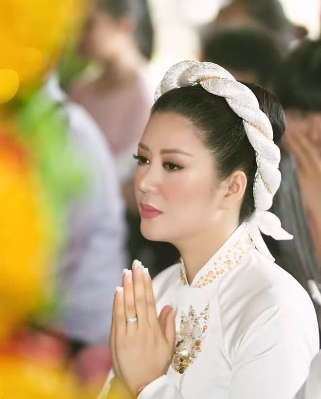 Nữ ca sĩ mang vẻ đẹp đằm thắm dịu dàng. Trong lễ cưới theo nghi thức Phật giáo, Đinh Hiền Anh chọn lựa áo dài trắng thêu hoa tay.