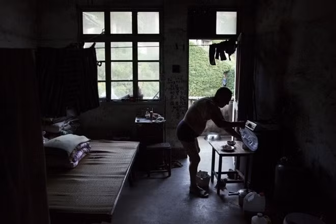 Sun Ayue, một trong số ít các cư dân còn lại của Houtouwan, chuẩn bị bữa tối trong căn phòng nơi ông sống. Người đàn ông 59 tuổi này từng là một ngư dân.
