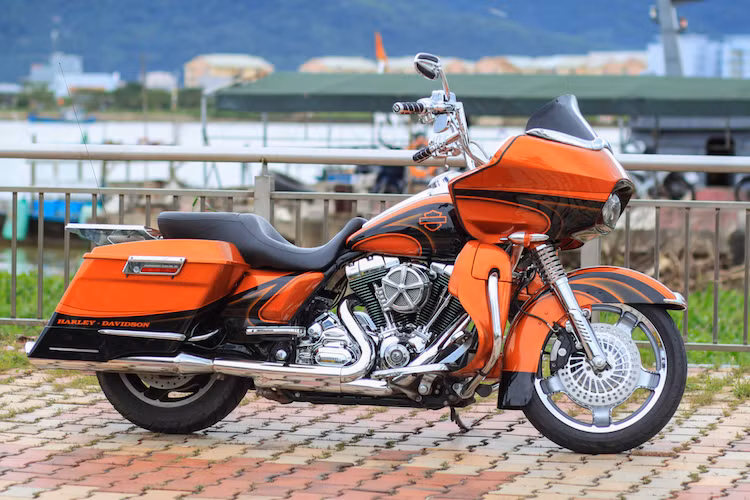 Cặp phuộc trước của chiếc Road Glide này cũng có vỏ phuộc mới với những gân nổi đầy mạnh mẽ. Trong khi đó, toàn bộ thân xe đã được sơn lại trong tông màu cam rực rỡ với các họa tiết trang trí màu đen tương phản theo phong cách của nhiều dòng Harley-Davidson CVO.