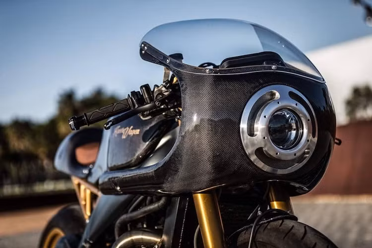 Để tạo cho RSV 1000 bộ vỏ mới theo phong cách cafe racer cổ điển, Kacerwagen đã sử dụng đất sét để chỉnh sửa và tạo hình vỏ xe cho tới khi đạt độ hoàn hảo tối đa. Chiếm trọn phần đầu xe là bộ quây gió lớn theo phong cách xe đua thập niên 60-70, với đèn pha trước dạng gương cầu LED được bắt vào quây gió bằng khung nhôm CNC tinh xảo.