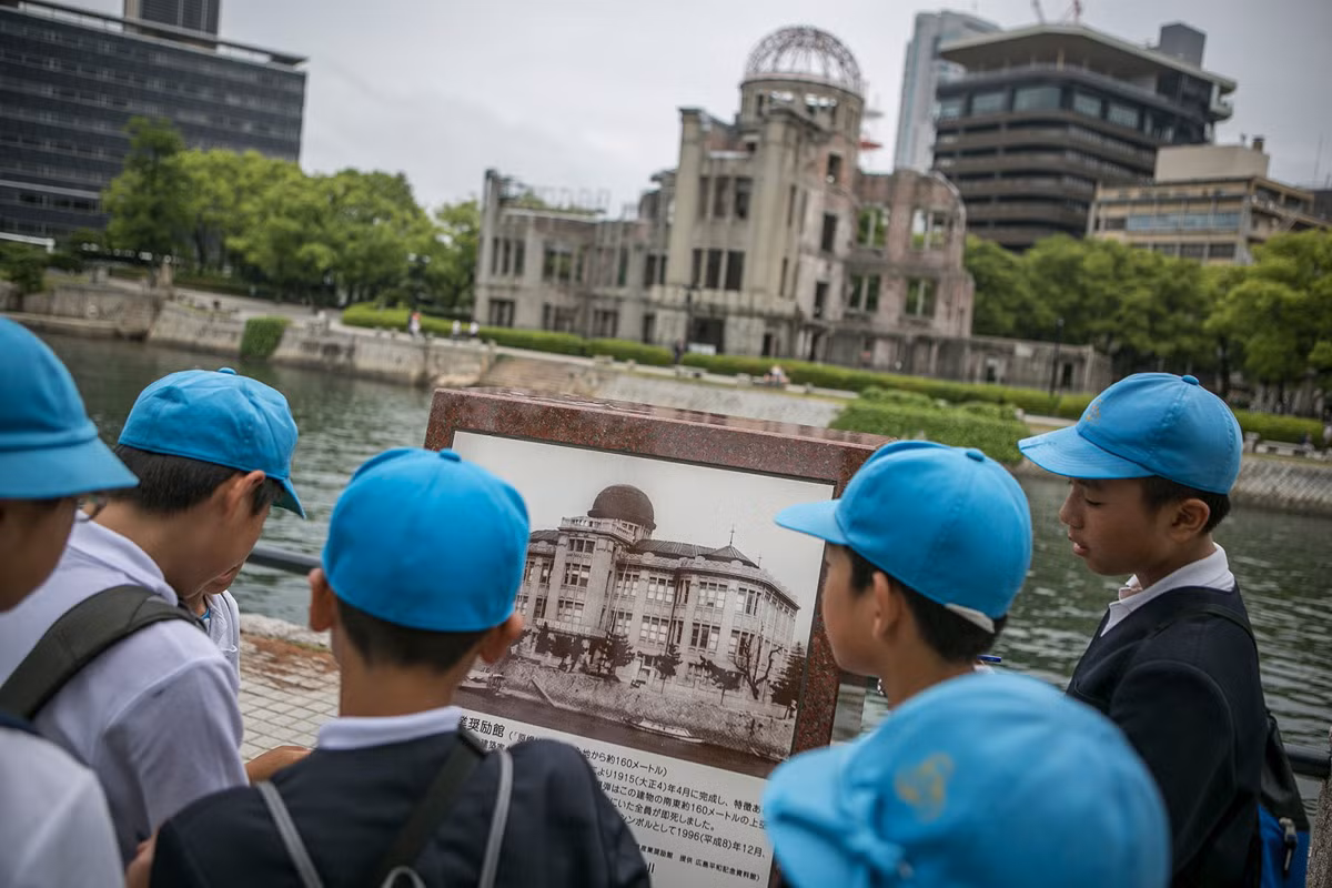 Các em nhỏ đang nhìn một bức ảnh cũ chụp Mái vòm nguyên tử tưởng niệm thảm họa Hiroshima. Ảnh chụp ngày 26/5/2016, một ngày trước khi Tổng thống Mỹ Barack Obama tới thăm thành phố Hiroshima.